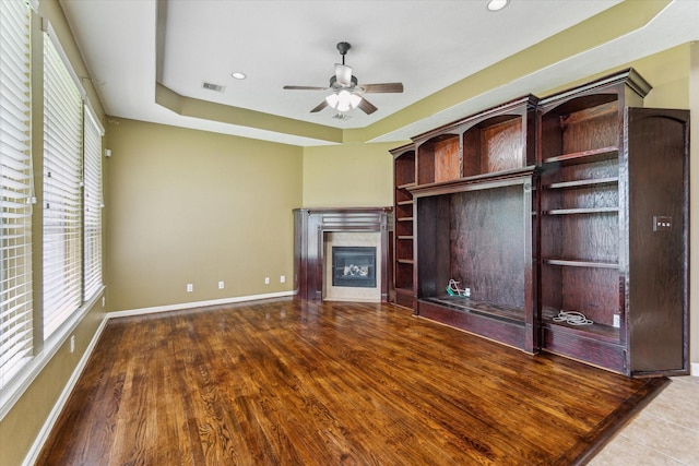 10707 Mandavilla Dr, Houston, TX 77095 - unfurnished living room with plenty of natural light, ceiling fan, a glass covered fireplace, and a tray ceiling