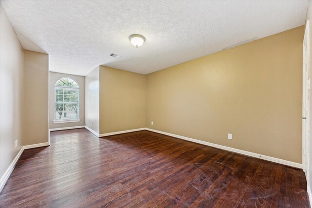 10707 Mandavilla Dr, Houston, TX 77095 - empty room with dark wood-style flooring, baseboards, and a textured ceiling