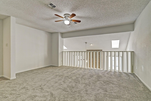 13948 Hollowgreen Dr Unit 25, Houston, TX 77082 - spare room featuring a ceiling fan, carpet floors, a textured ceiling, a skylight, and baseboards