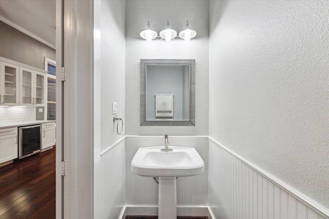 1032 W 18th St, Houston, TX 77008 - bathroom with wine cooler, decorative backsplash, wood finished floors, a wainscoted wall, and ornamental molding