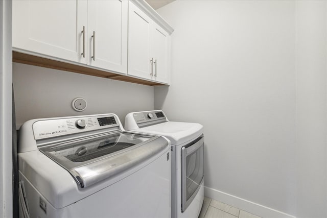 1032 W 18th St, Houston, TX 77008 - laundry room with cabinet space, washing machine and clothes dryer, baseboards, and light tile patterned floors