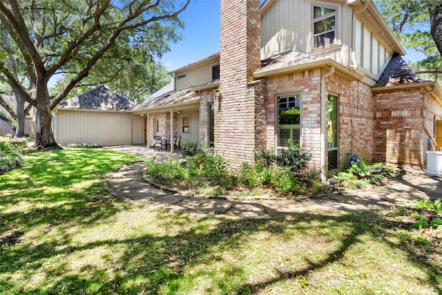 22015 Fielder Dr, Katy, TX 77450 - rear view of house featuring a patio area, a yard, brick siding, and a chimney