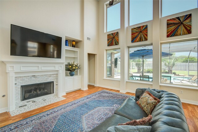 218 Moss Rose Ln, Lake Jackson, TX 77566 - living area featuring wood finished floors, baseboards, a tiled fireplace, and built in features