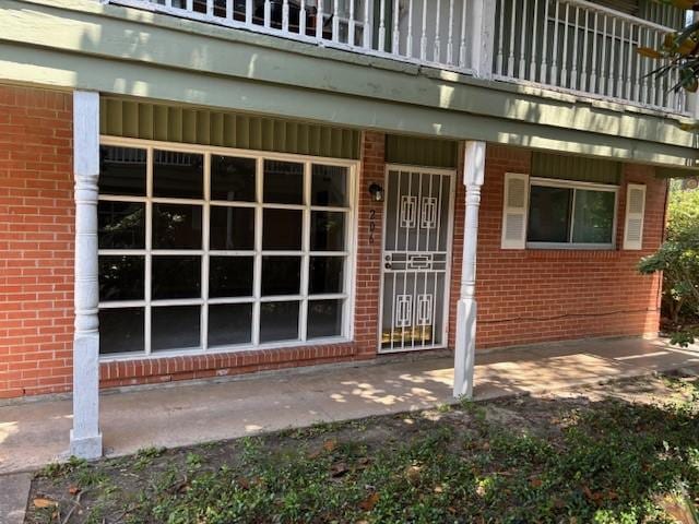 5542 Holly St Unit 206, Houston, TX 77081 - view of exterior entry with brick siding and covered porch