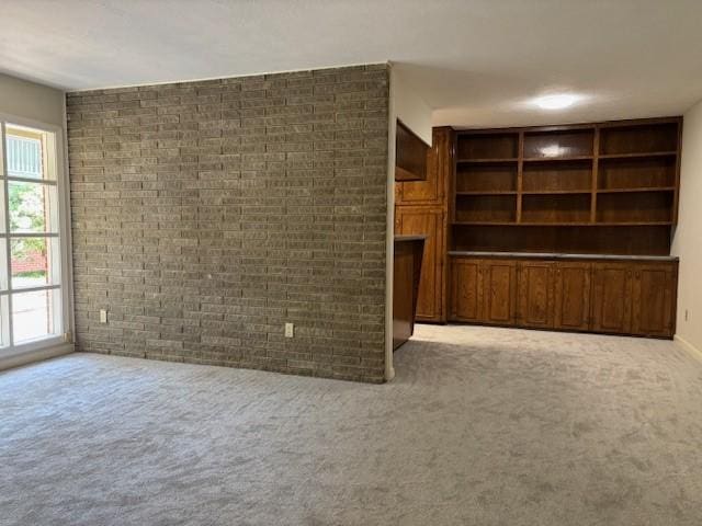 5542 Holly St Unit 206, Houston, TX 77081 - unfurnished living room featuring carpet flooring and brick wall