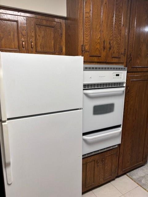 5542 Holly St Unit 206, Houston, TX 77081 - kitchen with white appliances, a warming drawer, and light tile patterned flooring