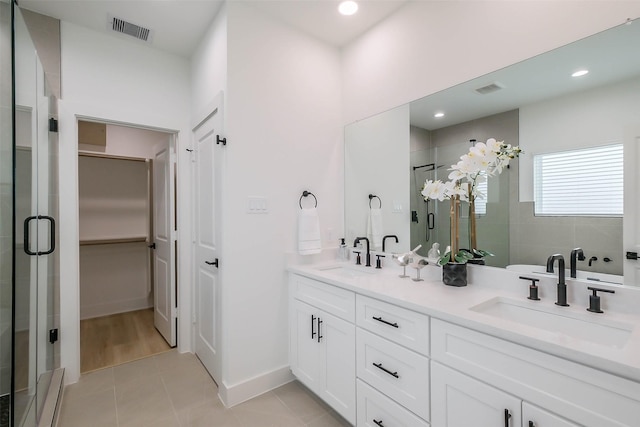 5703 Balbo St Unit B, Houston, TX 77091 - bathroom featuring a stall shower, a spacious closet, double vanity, tile patterned floors, and recessed lighting