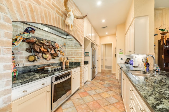 38 Adler Cir, Galveston, TX 77551 - kitchen with stainless steel appliances, a sink, decorative backsplash, dark stone countertops, and light stone finish floors