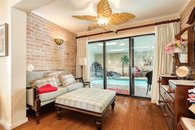 38 Adler Cir, Galveston, TX 77551 - living area with ornamental molding, dark wood finished floors, brick wall, and ceiling fan