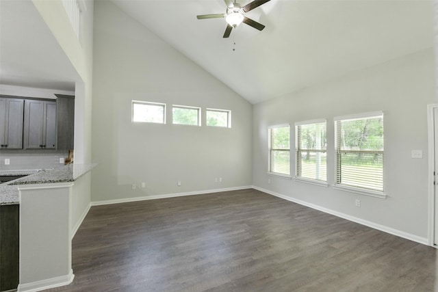 211 Rd 66111, Dayton, TX 77535 - unfurnished living room featuring high vaulted ceiling, ceiling fan, healthy amount of natural light, dark wood-type flooring, and baseboards