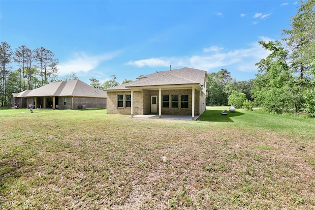 211 Rd 66111, Dayton, TX 77535 - back of house with a patio, a yard, roof with shingles, and brick siding