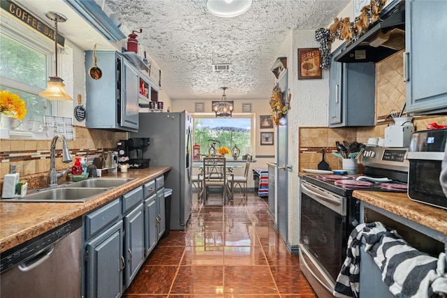 4931 Glendower Dr, Spring, TX 77373 - kitchen featuring appliances with stainless steel finishes, a sink, under cabinet range hood, tasteful backsplash, and a textured ceiling