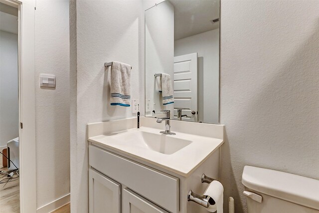 31611 Farlam Farms Trl, Fulshear, TX 77441 - half bath featuring toilet, vanity, a textured wall, and wood finished floors