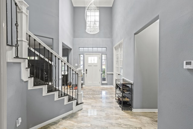 4914 Fern Cove Dr, Baytown, TX 77521 - entryway featuring a towering ceiling, marble tiled flooring, a chandelier, stairs, and baseboards