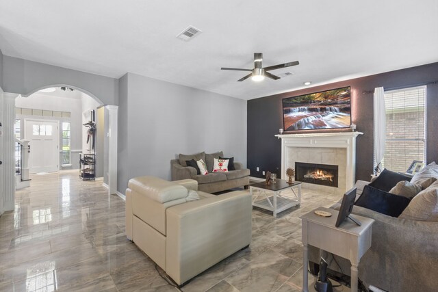 4914 Fern Cove Dr, Baytown, TX 77521 - living area with a ceiling fan, a fireplace, arched walkways, light marble finish floors, and baseboards