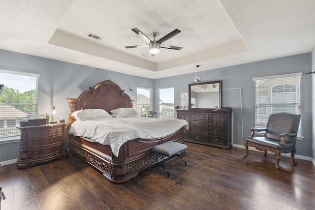 4914 Fern Cove Dr, Baytown, TX 77521 - bedroom featuring a tray ceiling, multiple windows, baseboards, and wood finished floors