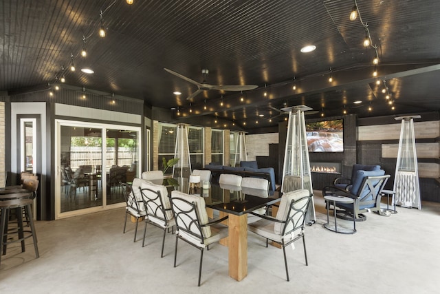 4914 Fern Cove Dr, Baytown, TX 77521 - dining room featuring concrete floors, a warm lit fireplace, and vaulted ceiling
