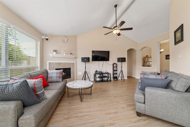 8123 Solara Bnd, Houston, TX 77083 - living area with light wood-type flooring, beam ceiling, ceiling fan, arched walkways, and a tile fireplace