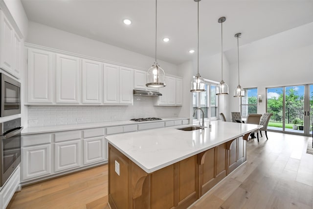 510 Rita Blanca Dr, Webster, TX 77598 - kitchen featuring a sink, appliances with stainless steel finishes, backsplash, light wood-style floors, and healthy amount of natural light