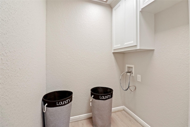 240 Sleepy Hollow Dr, Lake Jackson, TX 77566 - laundry area with cabinet space, light wood-style flooring, hookup for a washing machine, baseboards, and a textured wall