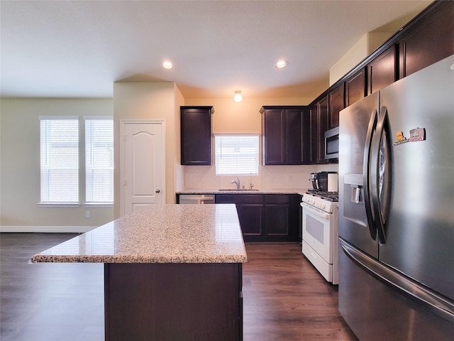3430 Hughes Meadow Way, Richmond, TX 77406 - kitchen featuring stainless steel appliances, a sink, a kitchen island, light stone countertops, and dark wood-style flooring