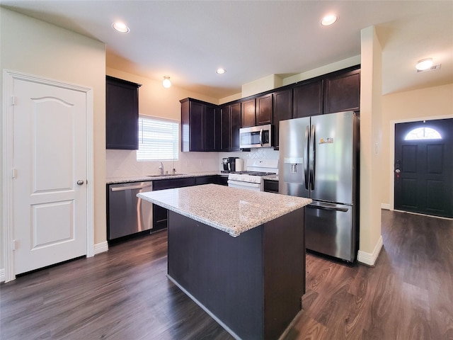 3430 Hughes Meadow Way, Richmond, TX 77406 - kitchen with appliances with stainless steel finishes, tasteful backsplash, a kitchen island, dark wood-type flooring, and dark brown cabinetry
