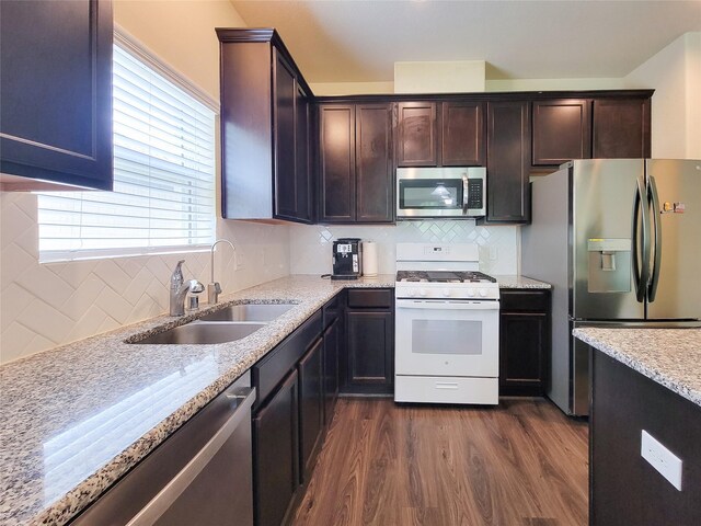 3430 Hughes Meadow Way, Richmond, TX 77406 - kitchen featuring appliances with stainless steel finishes, a sink, dark wood-type flooring, backsplash, and light stone countertops