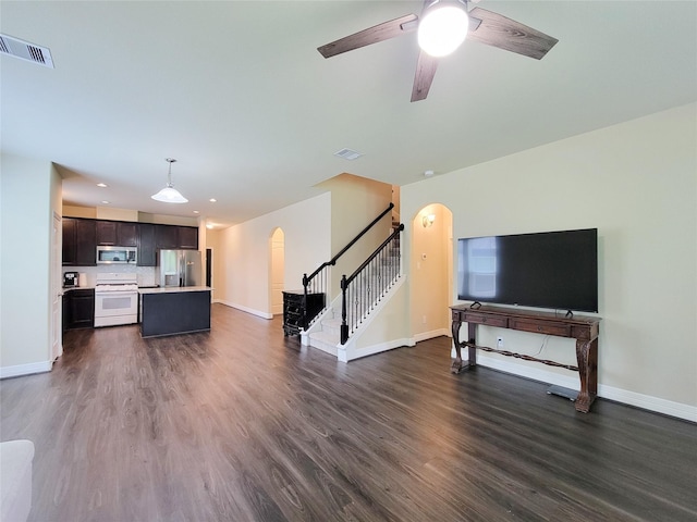 3430 Hughes Meadow Way, Richmond, TX 77406 - living room with arched walkways, baseboards, dark wood-type flooring, stairway, and a ceiling fan
