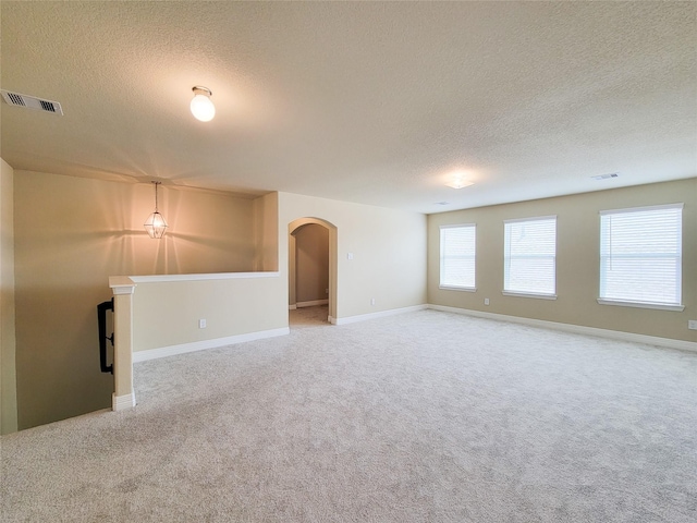 3430 Hughes Meadow Way, Richmond, TX 77406 - empty room with a textured ceiling, arched walkways, carpet flooring, and baseboards
