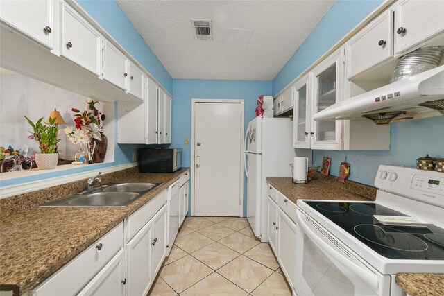 kitchen featuring white appliances, a sink, white cabinets, under cabinet range hood, and glass insert cabinets