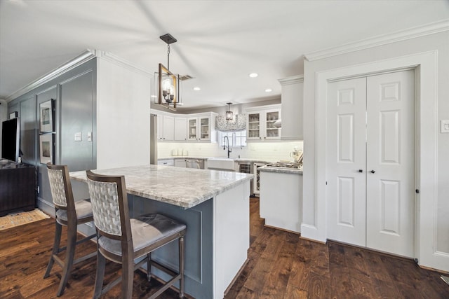 12310 Woodthorpe Ln, Houston, TX 77024 - kitchen featuring crown molding, white cabinets, recessed lighting, glass insert cabinets, and a sink