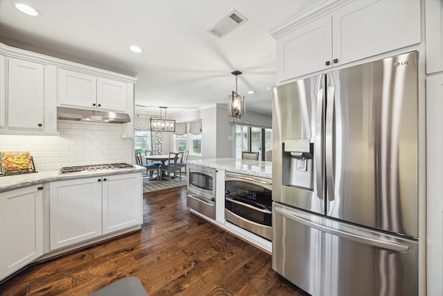12310 Woodthorpe Ln, Houston, TX 77024 - kitchen with stainless steel appliances, white cabinetry, dark wood finished floors, a warming drawer, and tasteful backsplash