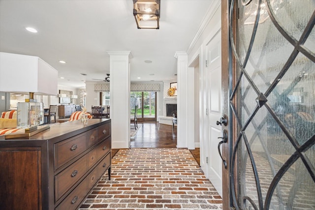 12310 Woodthorpe Ln, Houston, TX 77024 - entrance foyer featuring brick floors, ornate columns, baseboards, recessed lighting, and a brick fireplace