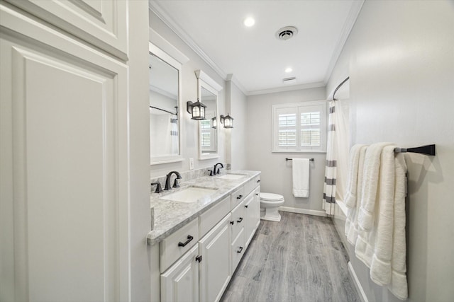 12310 Woodthorpe Ln, Houston, TX 77024 - bathroom with crown molding, toilet, wood finished floors, double vanity, and baseboards
