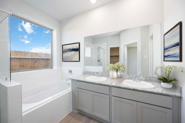 11765 Whirlaway Dr, Willis, TX 77318 - full bath featuring a shower stall, a garden tub, double vanity, wood finished floors, and a walk in closet