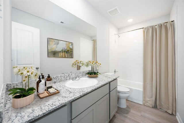 11765 Whirlaway Dr, Willis, TX 77318 - bathroom featuring wood finished floors, toilet, vanity, shower / bath combo, and recessed lighting
