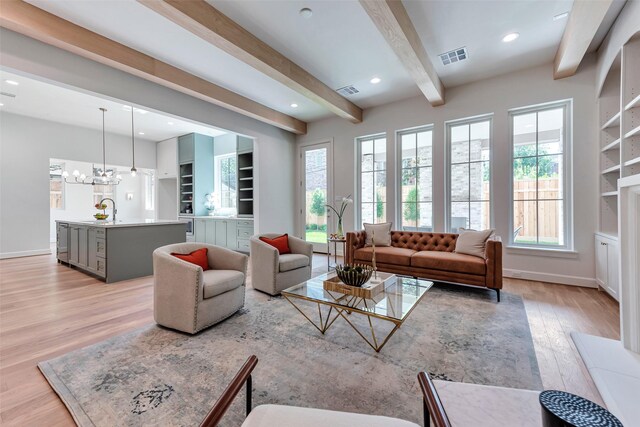 3314 La Salle St, Houston, TX 77027 - living room with light wood finished floors, beam ceiling, plenty of natural light, a chandelier, and built in shelves