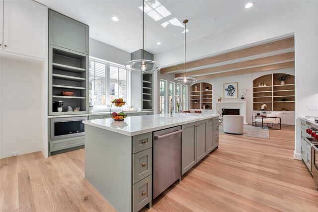 3314 La Salle St, Houston, TX 77027 - kitchen with stainless steel dishwasher, gray cabinets, open floor plan, a fireplace, and light wood finished floors
