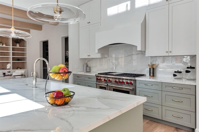 3314 La Salle St, Houston, TX 77027 - kitchen featuring range with two ovens, backsplash, light stone counters, pendant lighting, and light wood-style floors