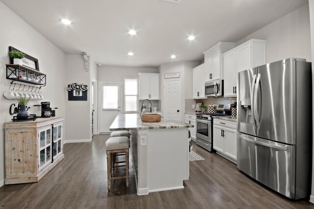 17723 Chartertree Ln, Tomball, TX 77377 - kitchen featuring appliances with stainless steel finishes, an island with sink, white cabinets, and recessed lighting