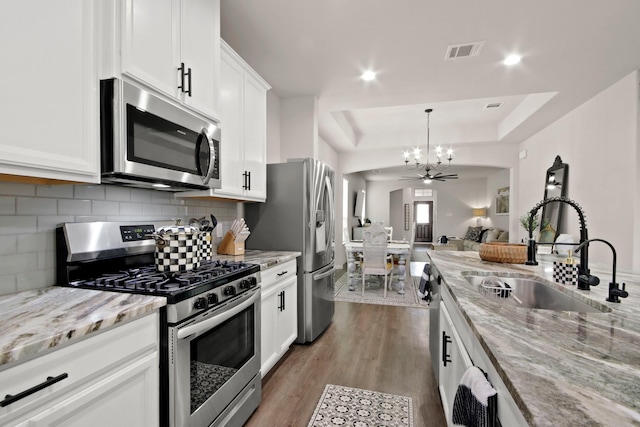 17723 Chartertree Ln, Tomball, TX 77377 - kitchen with appliances with stainless steel finishes, a sink, a chandelier, open floor plan, and light wood-style floors