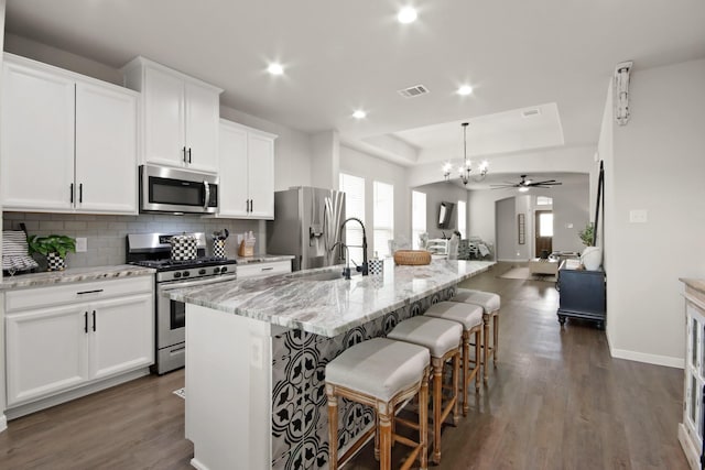 17723 Chartertree Ln, Tomball, TX 77377 - kitchen with appliances with stainless steel finishes, open floor plan, a chandelier, decorative backsplash, and dark wood finished floors