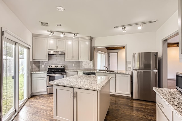 6509 Birdwood Rd, Houston, TX 77074 - kitchen with appliances with stainless steel finishes, under cabinet range hood, a sink, rail lighting, and dark wood finished floors