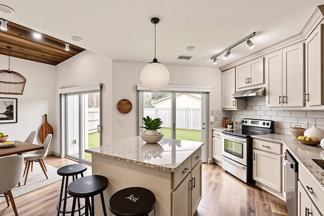 6509 Birdwood Rd, Houston, TX 77074 - kitchen with appliances with stainless steel finishes, under cabinet range hood, rail lighting, and tasteful backsplash