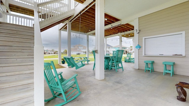 985 Sue Dr, Crystal Beach, TX 77650 - view of patio featuring outdoor dining area, a residential view, and stairs