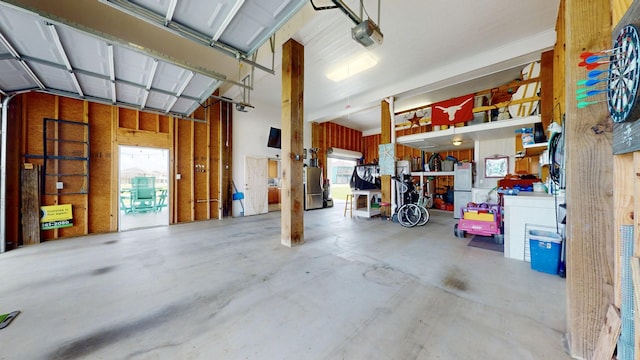 985 Sue Dr, Crystal Beach, TX 77650 - garage with a garage door opener and freestanding refrigerator