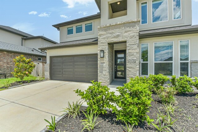 21606 Laggan Cliff Ln, Cypress, TX 77433 - view of front of home with an attached garage, stucco siding, stone siding, driveway, and fence