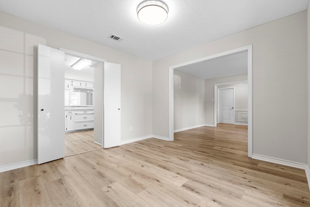 5310 Brownlee Ln, Spring, TX 77379 - spare room featuring light wood-type flooring, baseboards, and a textured ceiling