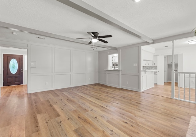 5310 Brownlee Ln, Spring, TX 77379 - unfurnished living room featuring a decorative wall, ceiling fan, light wood-style floors, and a textured ceiling