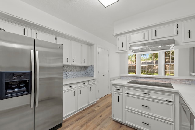 5310 Brownlee Ln, Spring, TX 77379 - kitchen with stainless steel refrigerator with ice dispenser, black electric cooktop, under cabinet range hood, decorative backsplash, and light countertops